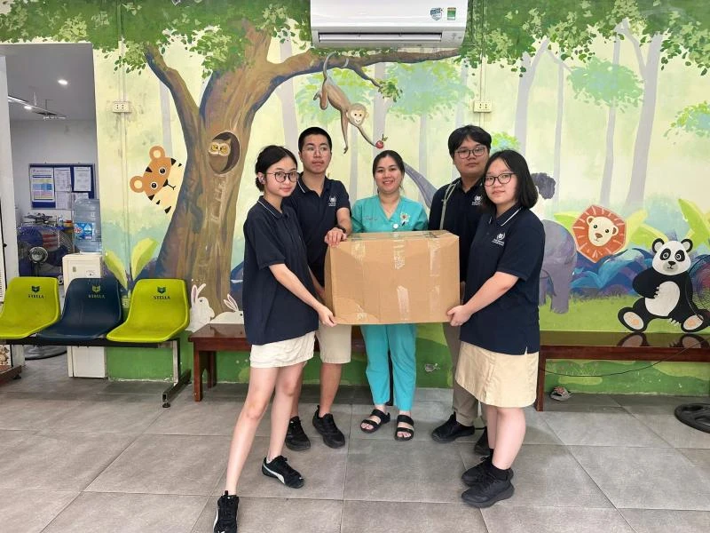 Student volunteers handing over clothing at Vietnam–Cuba Friendship Hospital
